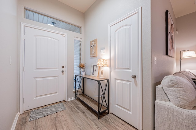 foyer entrance with light wood-type flooring and baseboards