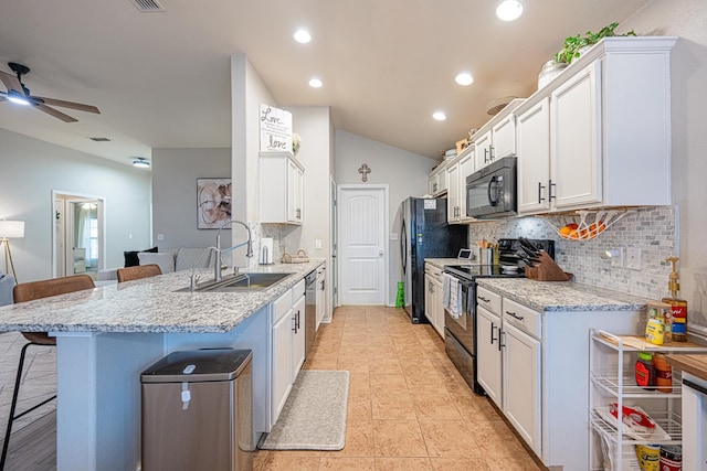 kitchen with black appliances, a sink, a kitchen breakfast bar, a peninsula, and backsplash