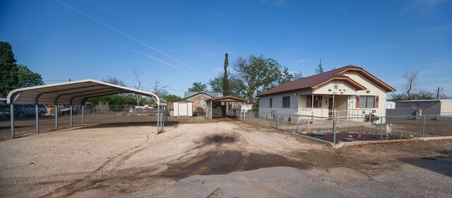 view of front of property with a storage shed and a carport