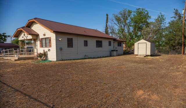 rear view of house featuring a storage shed