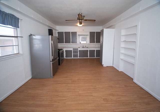 kitchen with light hardwood / wood-style flooring, ceiling fan, sink, built in shelves, and stainless steel appliances