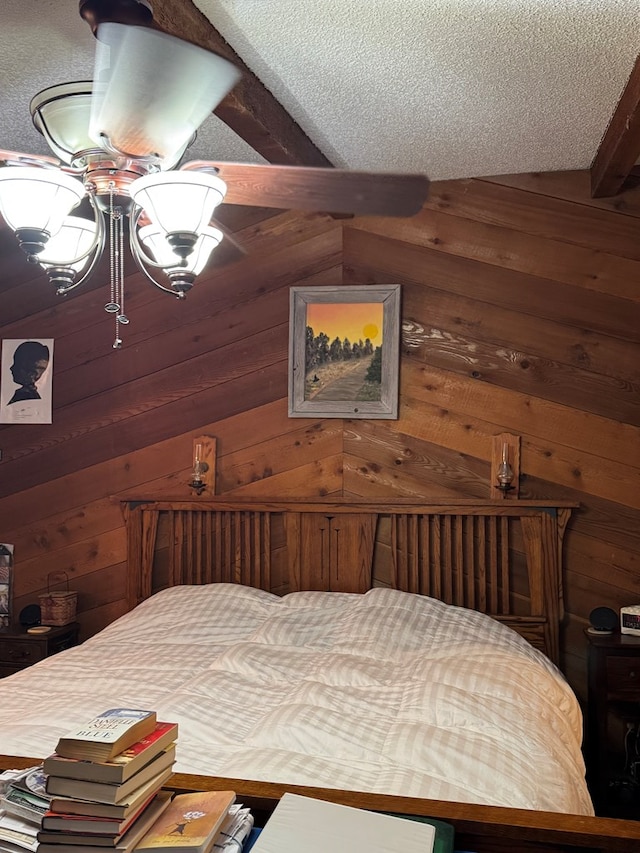 bedroom featuring a textured ceiling and wood walls