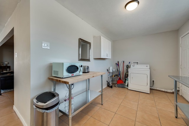 2724 E 11th St, Odessa, TX 79761 - laundry area featuring light tile patterned floors, cabinet space, washer and clothes dryer, and baseboards