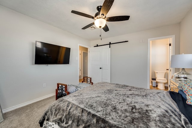 2724 E 11th St, Odessa, TX 79761 - carpeted bedroom with visible vents, a barn door, connected bathroom, baseboards, and ceiling fan