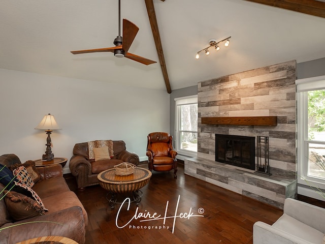 living area featuring vaulted ceiling with beams, ceiling fan, a fireplace, and wood finished floors