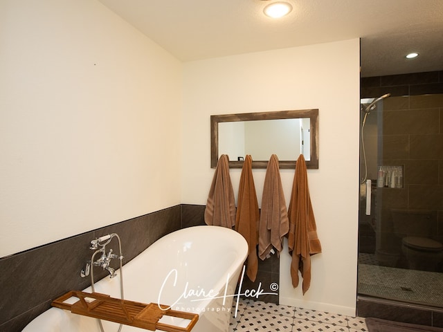 bathroom with a stall shower, a soaking tub, and recessed lighting