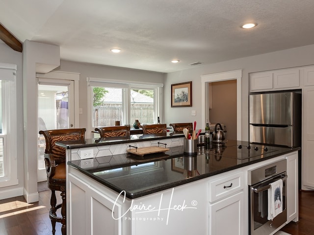 kitchen with white cabinetry, visible vents, appliances with stainless steel finishes, and dark wood finished floors