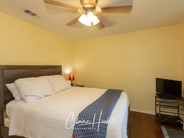 bedroom featuring visible vents, ceiling fan, baseboards, and wood finished floors