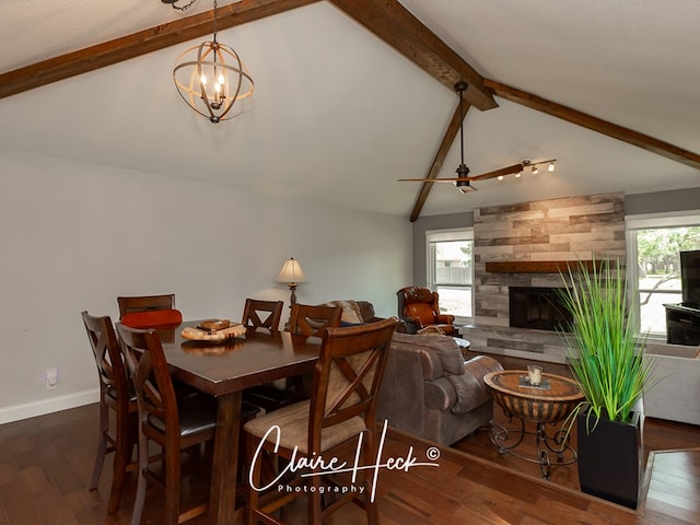 dining area with a fireplace, lofted ceiling with beams, wood finished floors, baseboards, and ceiling fan with notable chandelier