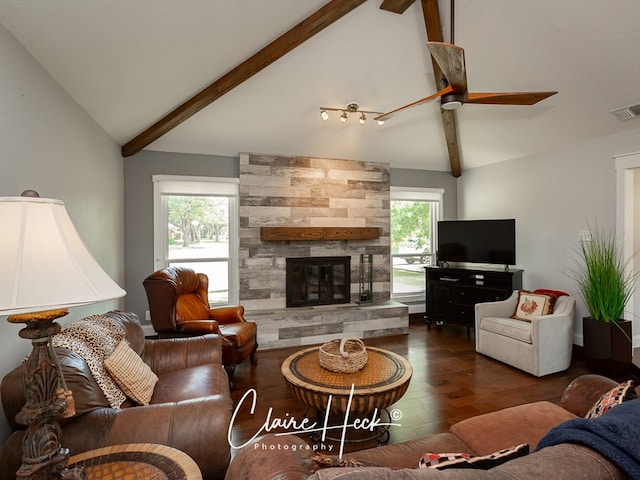 living area with visible vents, a fireplace, wood finished floors, and beam ceiling