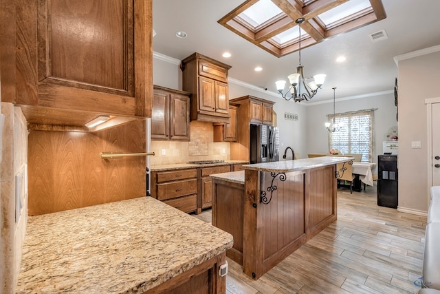 kitchen featuring black refrigerator with ice dispenser, crown molding, light hardwood / wood-style flooring, a skylight, and a chandelier