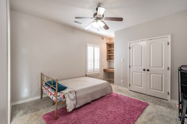 carpeted bedroom with ceiling fan and a closet