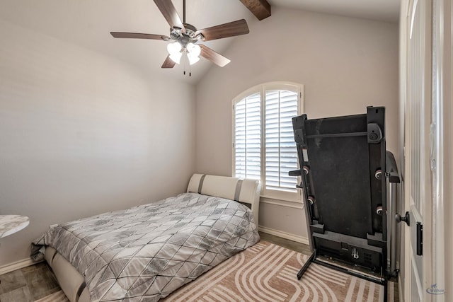 bedroom featuring ceiling fan, wood-type flooring, and vaulted ceiling with beams