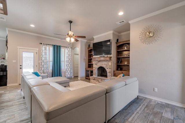 living room with ceiling fan, crown molding, and a fireplace