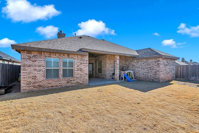 back of house featuring a patio area and a lawn