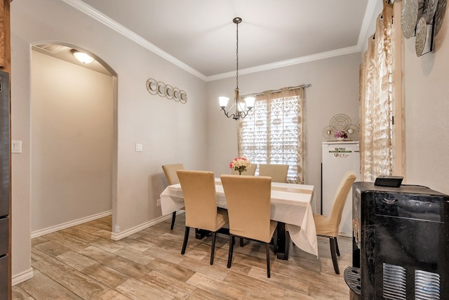 dining area with ornamental molding, a chandelier, and light wood-type flooring