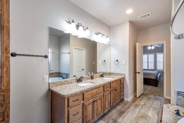 bathroom with a bath, ceiling fan, and vanity