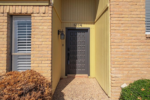 doorway to property featuring brick siding