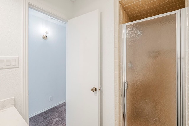 bathroom featuring a shower stall and baseboards