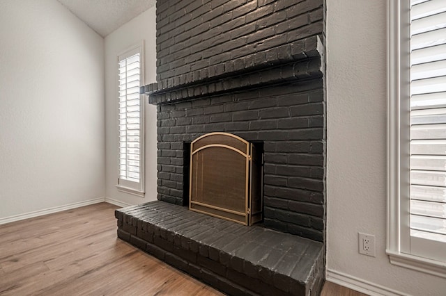 interior details with a fireplace, baseboards, and wood finished floors