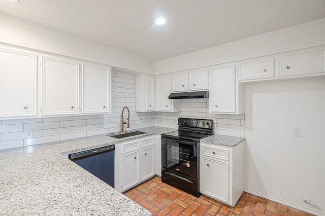 kitchen with tasteful backsplash, white cabinets, under cabinet range hood, black appliances, and a sink