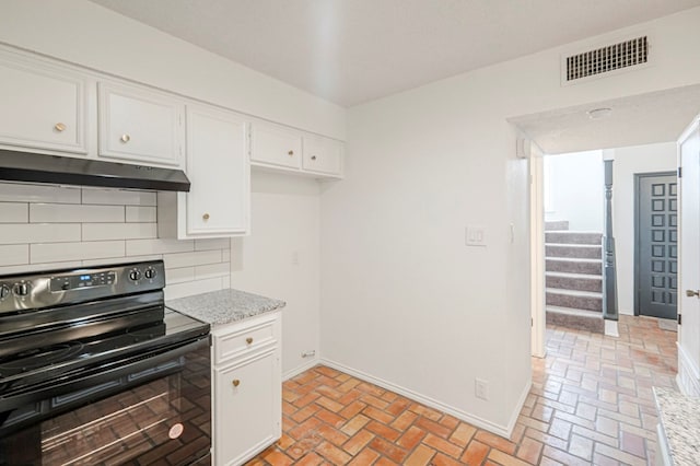 kitchen featuring under cabinet range hood, visible vents, white cabinets, black electric range, and decorative backsplash