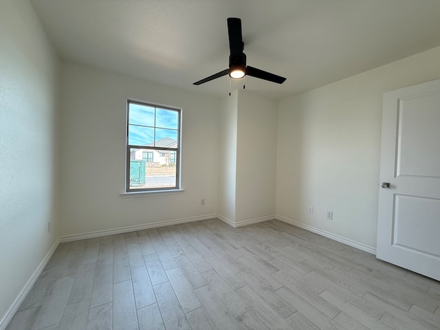 unfurnished room featuring ceiling fan, wood finished floors, and baseboards