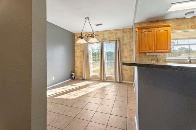 kitchen featuring sink, light tile patterned flooring, and hanging light fixtures