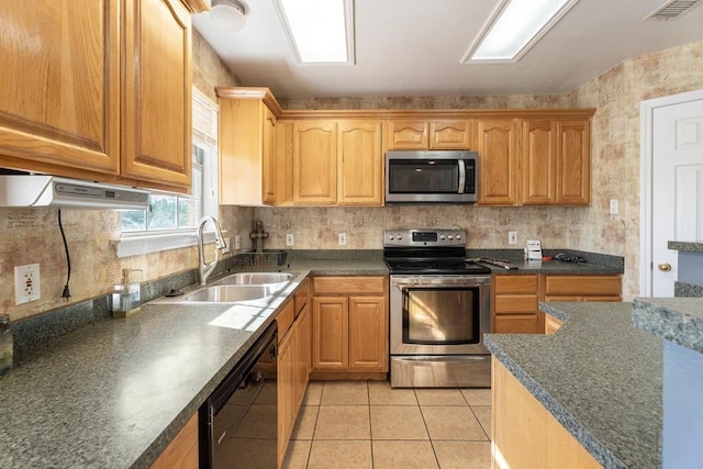 kitchen featuring light tile patterned flooring, appliances with stainless steel finishes, and sink