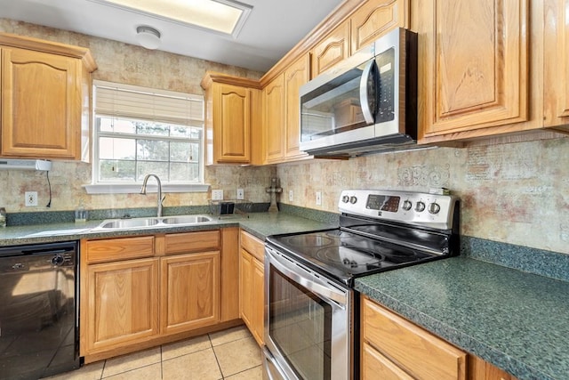 kitchen featuring light tile patterned floors, sink, appliances with stainless steel finishes, and tasteful backsplash