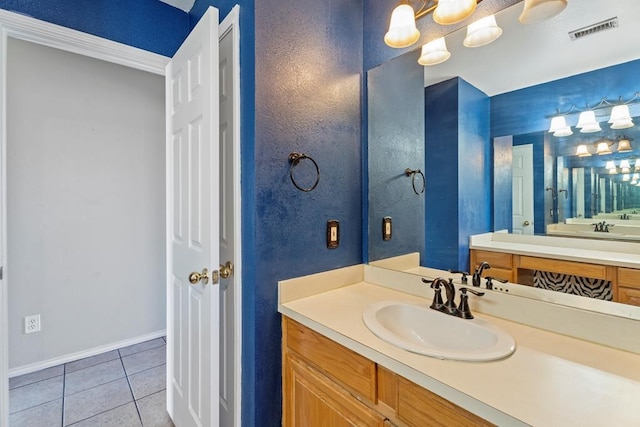 bathroom with tile patterned flooring, vanity, and a notable chandelier