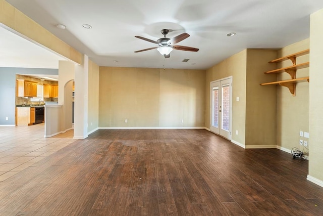 unfurnished living room with ceiling fan, hardwood / wood-style floors, and french doors