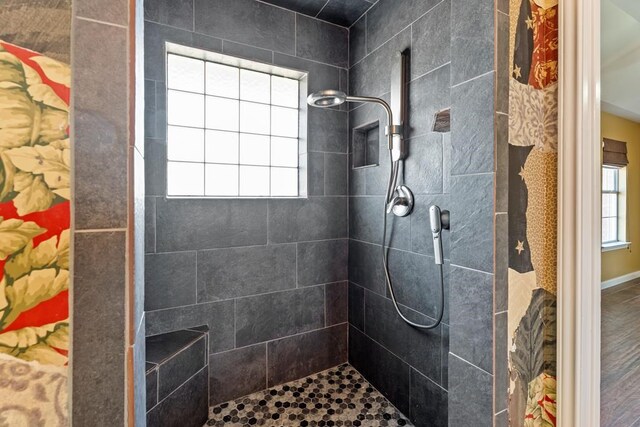 bathroom featuring a tile shower and hardwood / wood-style flooring