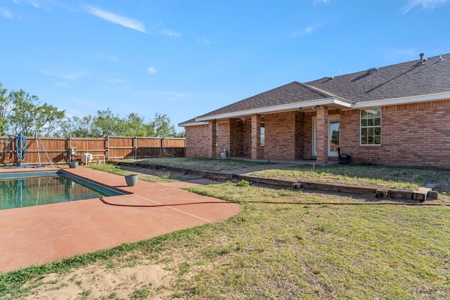 view of pool with a patio area and a yard