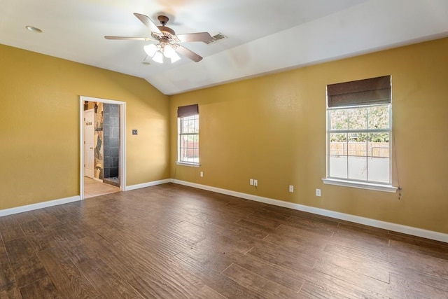 empty room featuring hardwood / wood-style floors, vaulted ceiling, and plenty of natural light