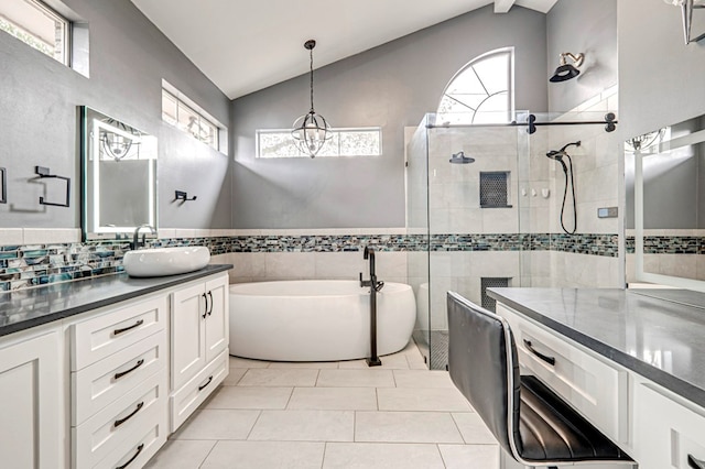 bathroom featuring vaulted ceiling, a wealth of natural light, and tile walls