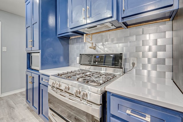 kitchen featuring light countertops, light wood-style flooring, backsplash, double oven range, and blue cabinetry
