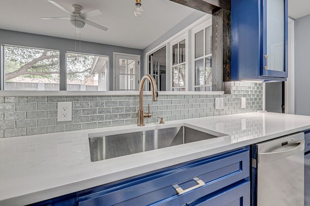kitchen with a sink, decorative backsplash, stainless steel dishwasher, and blue cabinetry