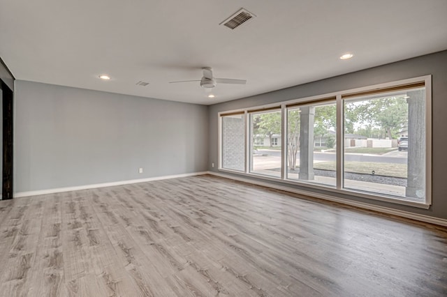 spare room featuring a ceiling fan, baseboards, visible vents, and wood finished floors