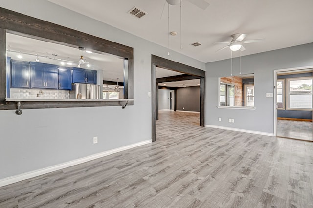 unfurnished living room with ceiling fan, wood finished floors, and visible vents