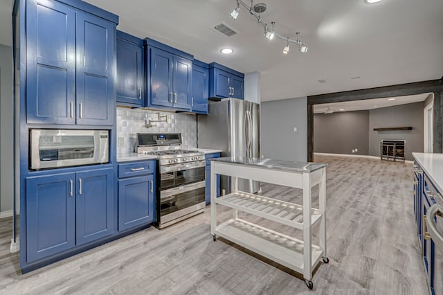 kitchen with light countertops, stainless steel appliances, blue cabinets, and visible vents