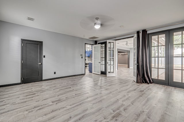 spare room featuring french doors, ceiling fan, wood finished floors, and visible vents