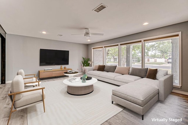 living room featuring recessed lighting, baseboards, light wood finished floors, and visible vents