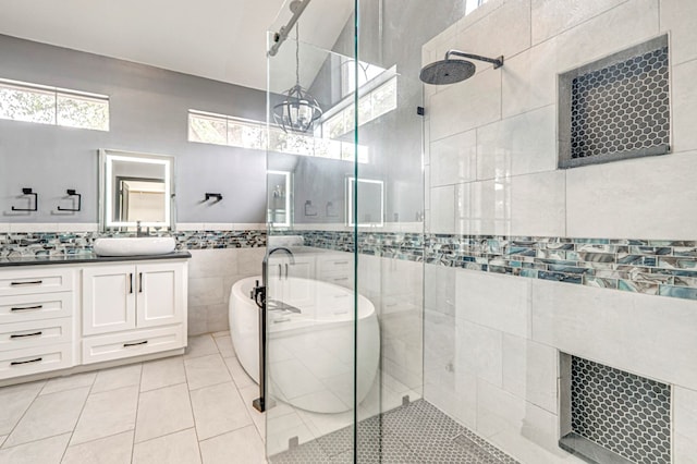 bathroom with tile walls, a freestanding tub, a shower stall, vanity, and tile patterned floors