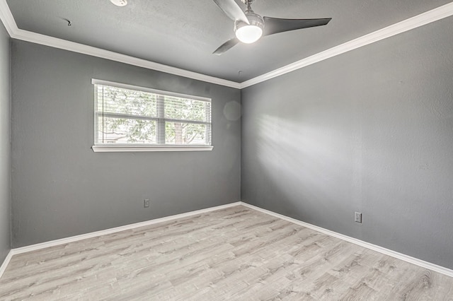 spare room with baseboards, ornamental molding, a ceiling fan, and wood finished floors