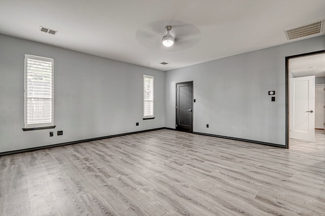 unfurnished room featuring light wood-style floors, a ceiling fan, and visible vents