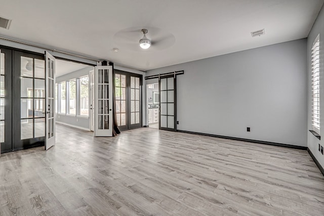 spare room featuring a ceiling fan, visible vents, french doors, and wood finished floors