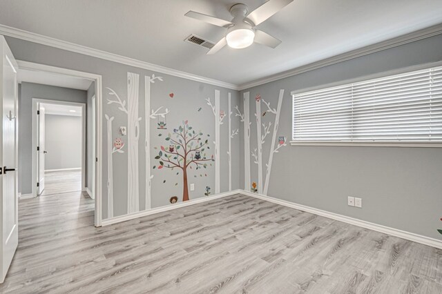 empty room with baseboards, ceiling fan, wood finished floors, and visible vents