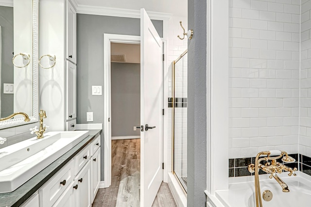 bathroom featuring crown molding, wood finished floors, a bath, and a stall shower