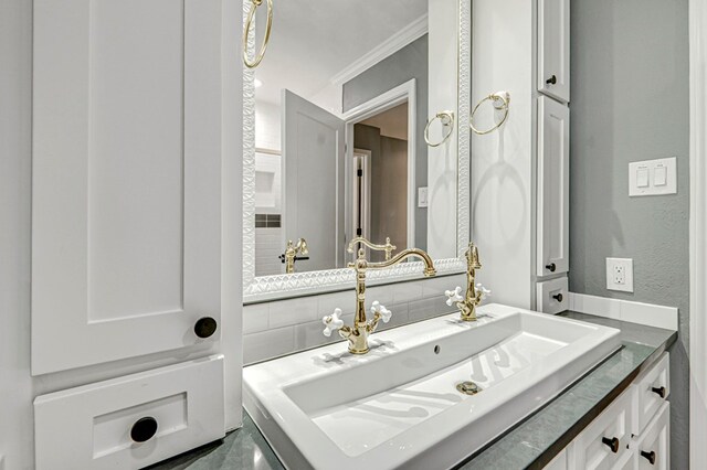 bathroom featuring crown molding and vanity